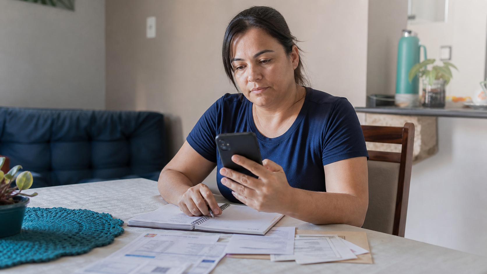Consumidora analisa o orçamento doméstico enquanto consulta o celular